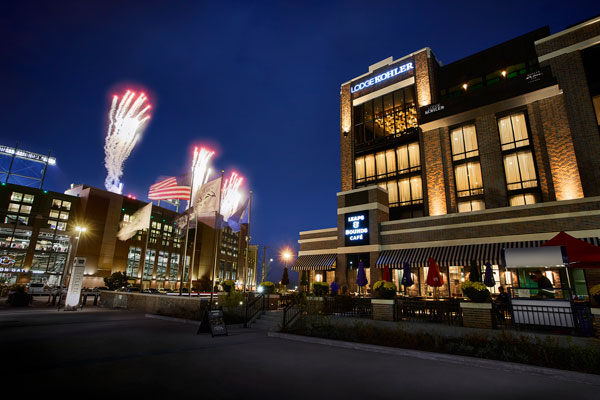 Lodge Kohler at night with fireworks shooting out of Lambeau Field in the background
