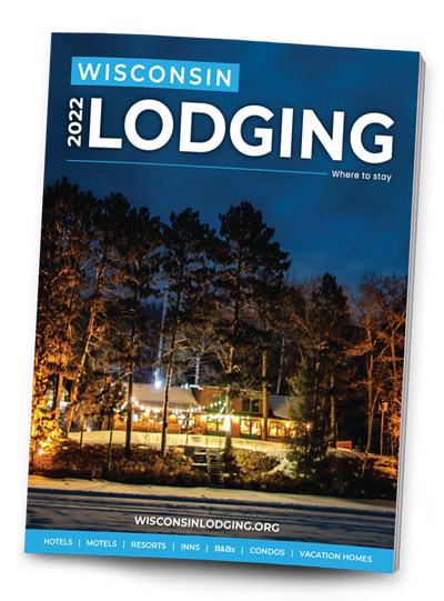 Cover image of the 2022 Wisconsin Lodging Directory. Photo of exterior of Pitlik's Sand Beach Resort (Eagle River, WI) at night surrounded by trees.