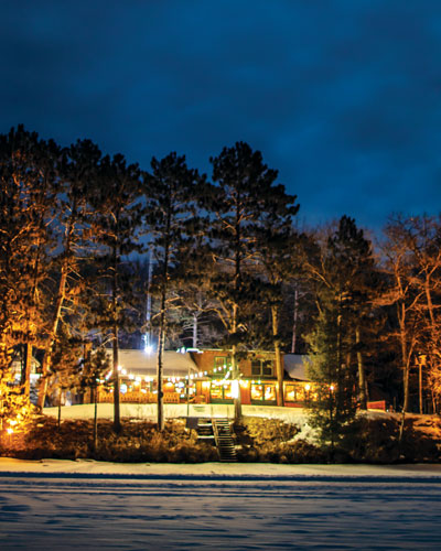 Exterior photo of Pitlik's Sand Beach Resort (Eagle River, WI) taken from out on the frozen lake at night.